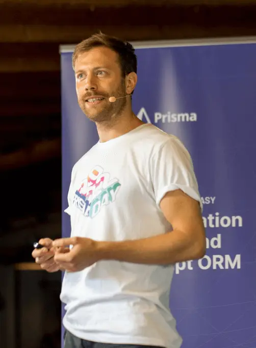 A Prisma team member presenting at a conference in front of a Prisma banner
